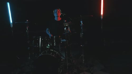Male Drummer Plays Drums Under Blue and Red Lights