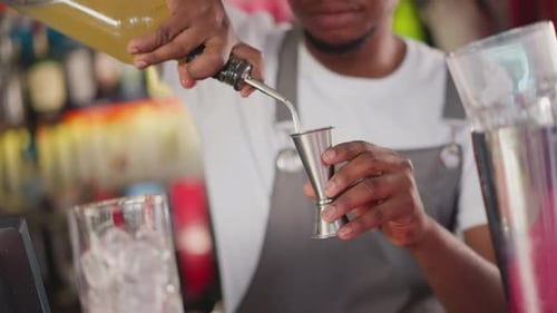 Barman Pours Liqueur Into Jigger in Club