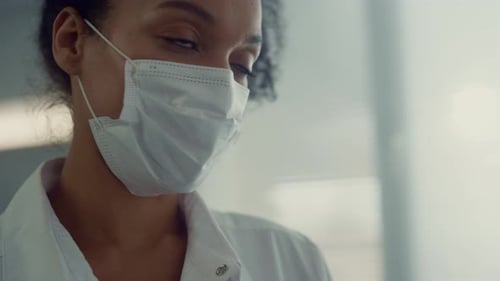 Retrato de uma jovem enfermeira africana bonita sorrindo conversando com o interlocutor na área médica