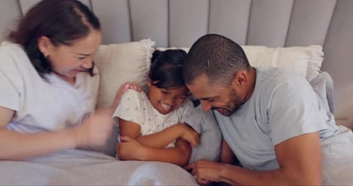 Loving Family Playing Together on Bed