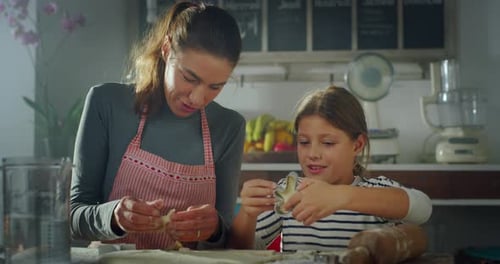 Mother and Daughter Baking Cookies Together at Home