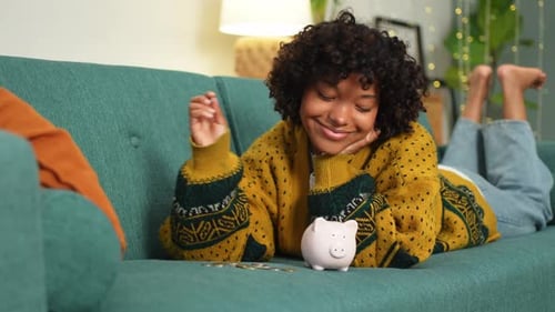 Saving Money Investment for Future African American Girl Putting Money Coin in Pink Piggy Bank