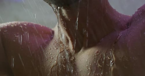 Close up of an young handsome man is taking a hot relaxing shower in a luxury wellness center.