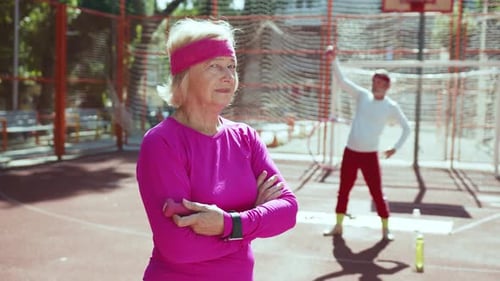 An Active Senior Woman Dressed in Sportswear on a Tennis Court Engaging in a Match