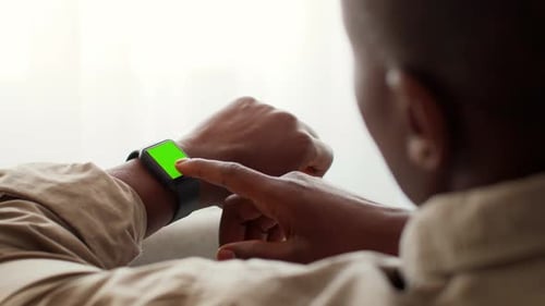 Man Using Smartwatch at Home While Interacting with Technology