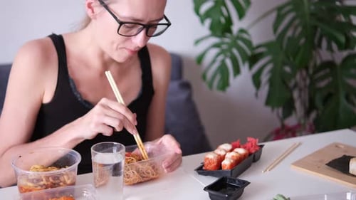 Woman Eating Noodles and Sushi with Chopsticks