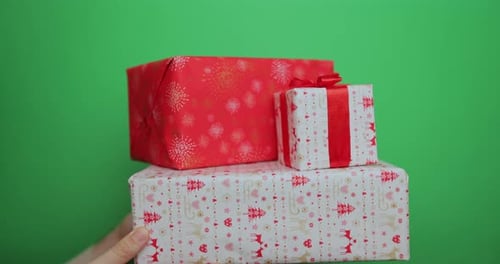Hand Passes Festive Christmas Gifts on Green Screen