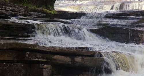 close up Shot of water cascading down Catrake Force, waterfall Upstream of the hamlet of keld,