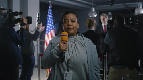 Reporter Speaking at a Press Conference Indoors