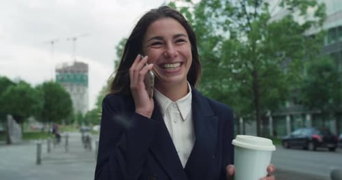 Smiling Woman Chatting on Phone and Drinking Coffee