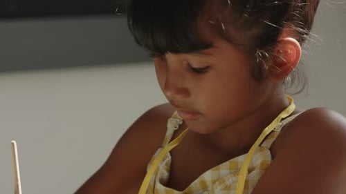 À l'école, l'enfant se concentre sur une tâche, tient un crayon et écrit en classe