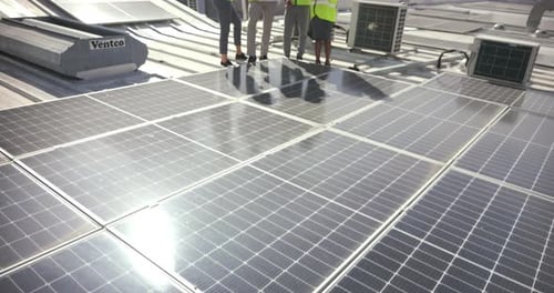 Solar panels, planning and construction workers with blueprint on roof, architecture