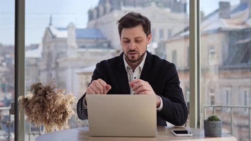 Man Working on Laptop in Urban Office Setting