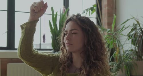 Mujer meditando con cristal curativo en casa