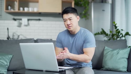 Man Video Conferencing on Laptop at Home