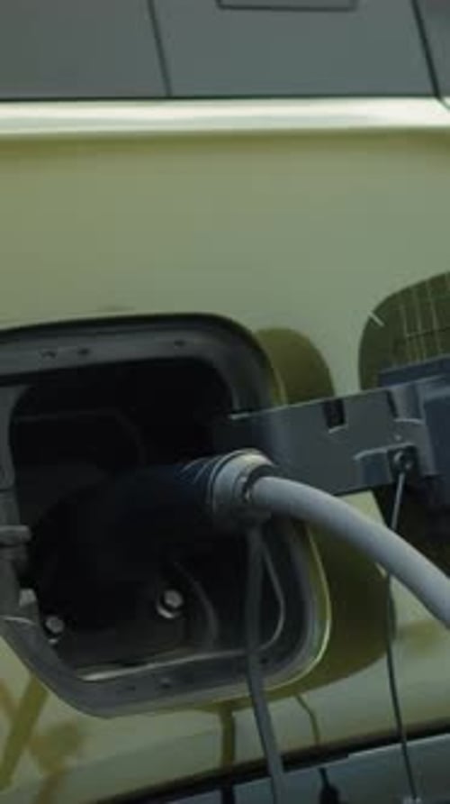 Vertical Video Closeup of EV Vehicle Connected to Charging Dock Emphasizing Sustainability