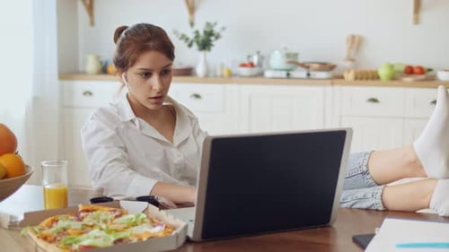Pretty Woman Sitting at the Kitchen and Work Remotely Woman Put Her Legs on the Table on the Table