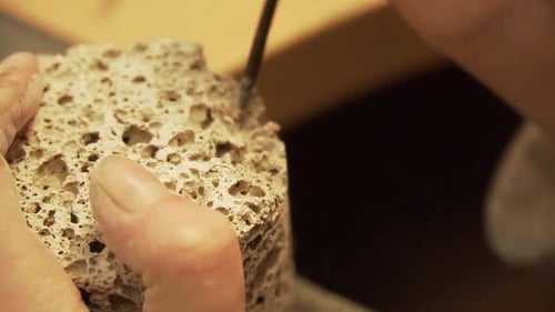 Zerbröckelnder Betonzylinder (Geopolymer) mit abgerundeter Feile - Nahaufnahme in slowmo