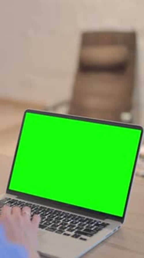 Young Woman Using Laptop with Green Screen, vertical video