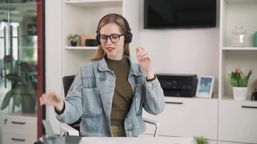 Woman Listening Music at Desk in Office