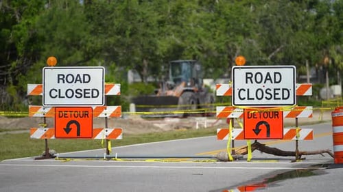 Yellow Protective Barrier at Street Construction Site Warning Road Sign About Utility Work