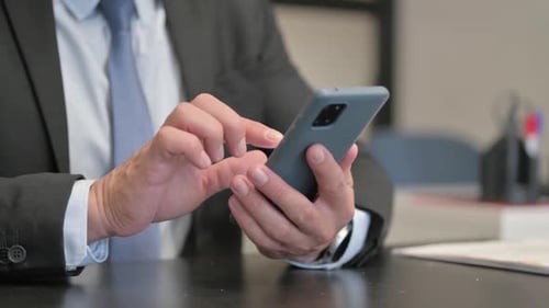 Close Up of Businessman Using Smartphone in Office