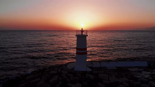 Drohnenblick auf Leuchtturm und Meer bei Sonnenuntergang