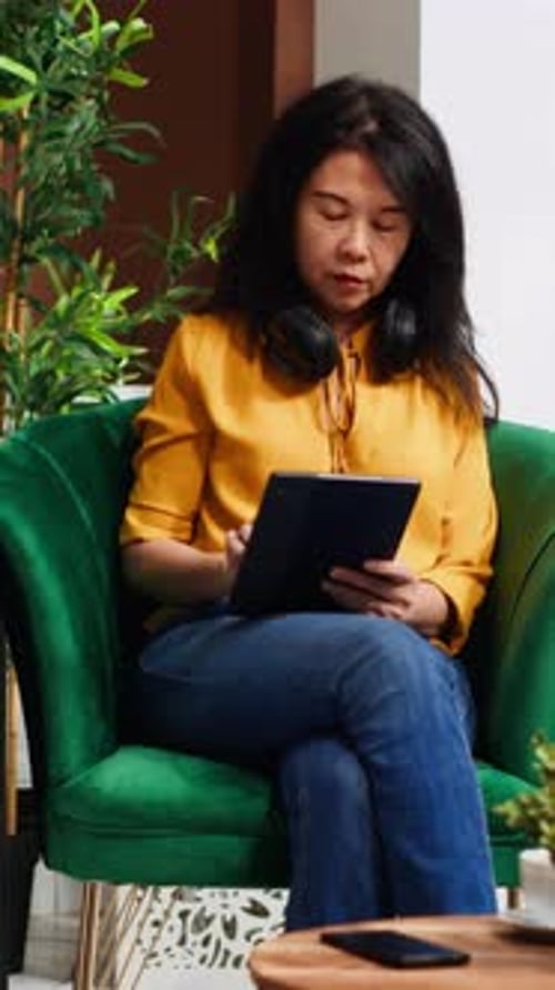 Vertical Video Young Traveler Using Tablet in Lounge Area at Hotel