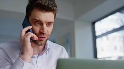 Young adult working on a laptop and smartphone