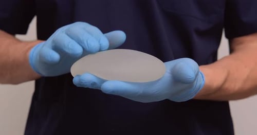 Person in Gloves Holding Breast Implant Close Up