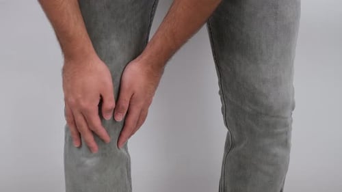 Adult Holding Knee in Pain, rubbing knee