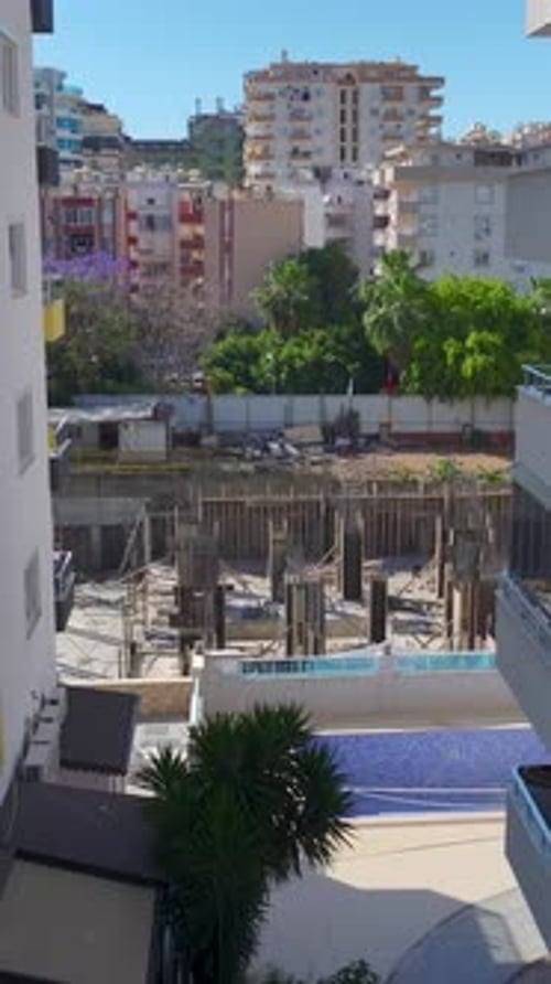 Vídeo vertical Los trabajadores de la construcción colocan ladrillos y construyen paredes en un sitio activo avanzando en la