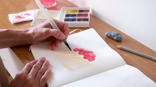 closeup of unrecognizable woman drawing with watercolor paint
