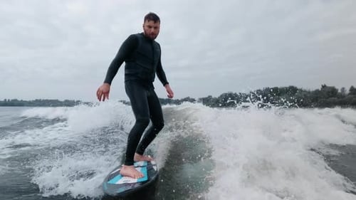 Surfer Skillfully Rides a Wave Showcasing Balance and Control in Dynamic Water Scene