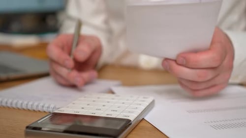 Man Calculating Monthly Home Expenses Taxes Bank Account Balance and Credit Card Bills Payment