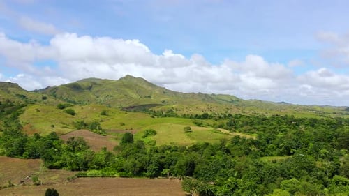 Hills with Green Grass and Blue Sky with White Puffy Clouds