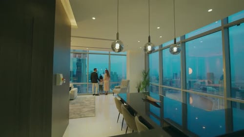 Family Gaze Overlooking City From Modern Apartment