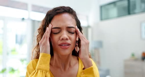 Stress, headache or burnout with a woman in the office, rubbing her temples while suffering