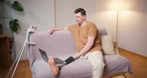 Man With Prosthetic Leg Using Laptop