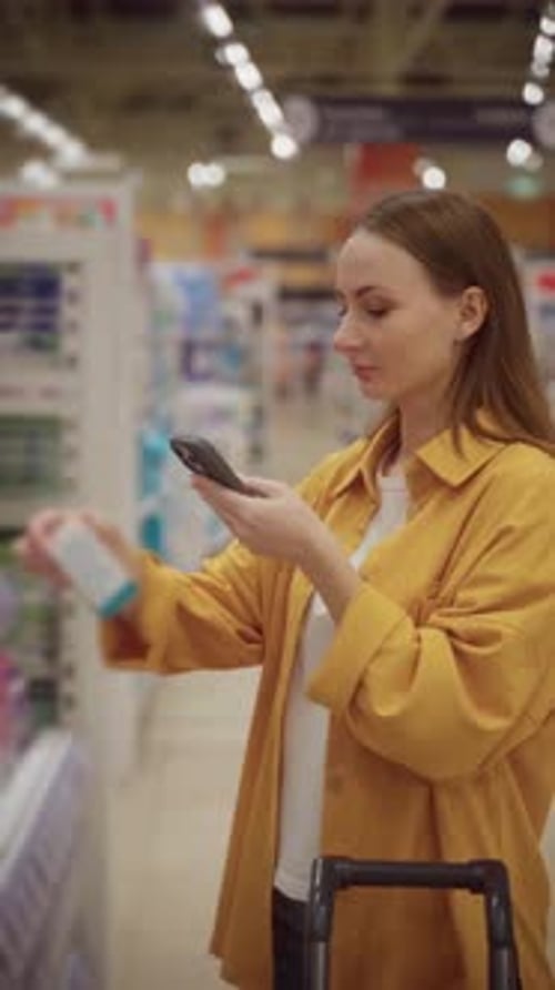 Selecting Cosmetics in a Store While Checking Details on a Smartphone