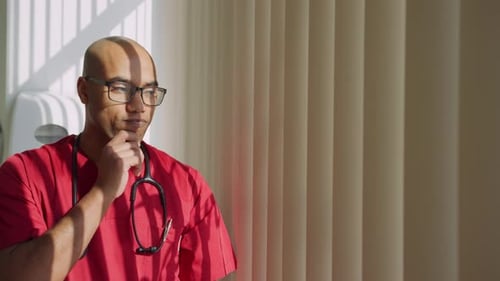 Thoughtful Medical Professional Standing in Hospital Room