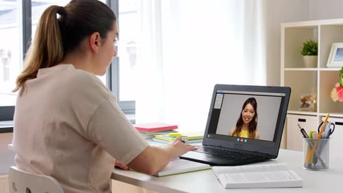 Woman Attends Online Class and Takes Notes