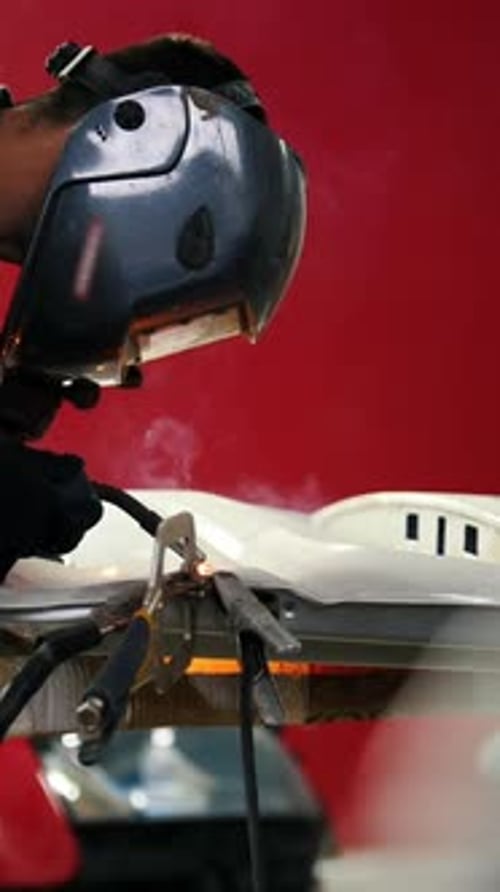 Welding Industrial Worker in Helmet Repair Detail in Car Auto
