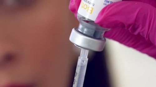 Female medical professional filling a syringe with Botox - close up