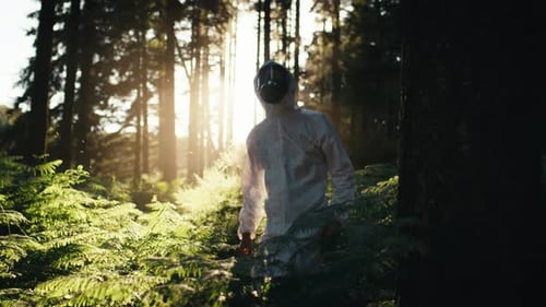 Mann desinfiziert den Wald im weißen Anzug von bakterieller Kontamination