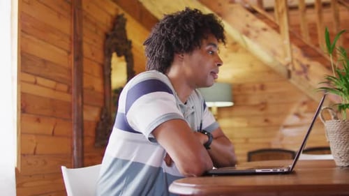 Young Adult on Laptop Video Call Waving