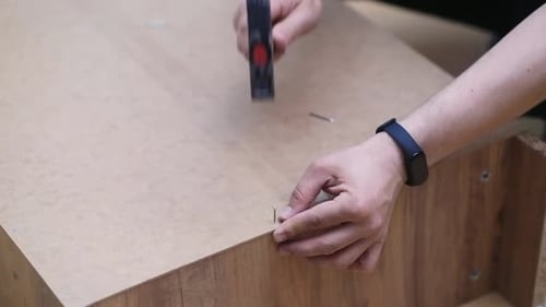 Furniture Assembly and Fixing Carpenter Hammering Nails Into Back of Office Rack