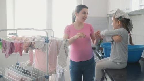 Mother and Child Hanging Laundry Together