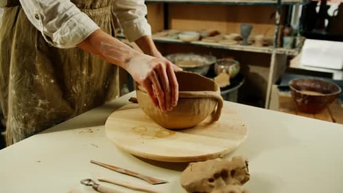 Creating handicraft pottery closeup of working table in ceramics studio with female master