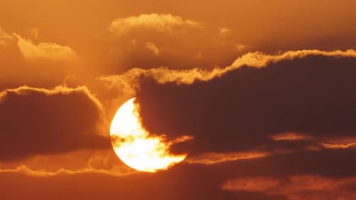 Die Sonne geht auf und die Wolken bewegen sich.